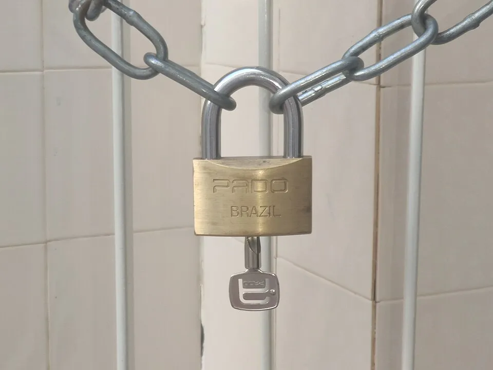 A padlock on a chain with its key left in the lock