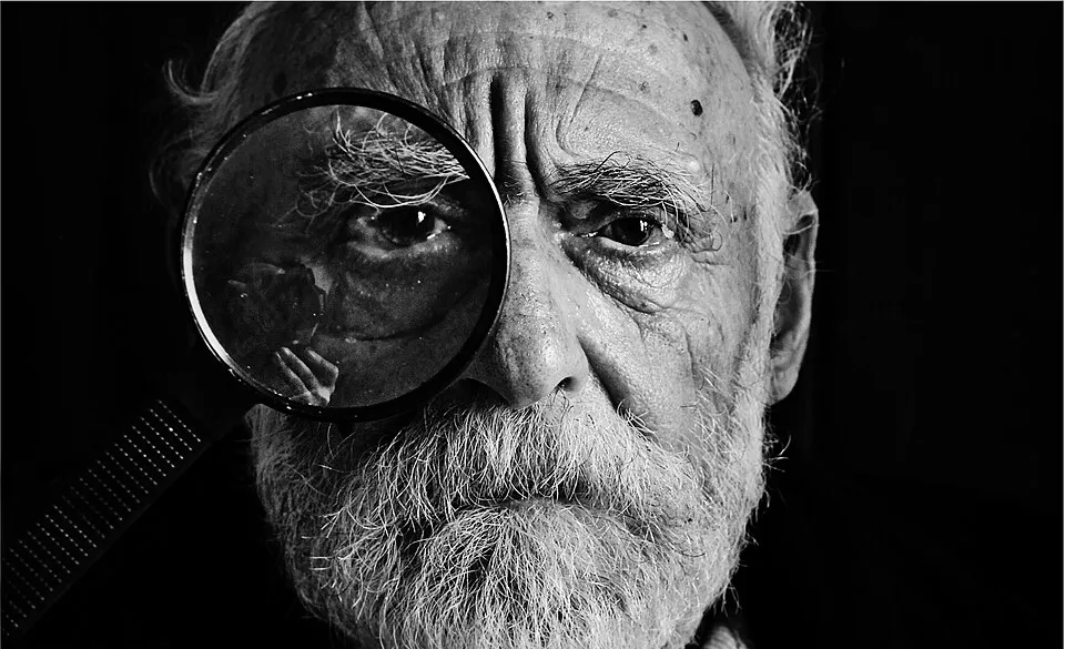 A man looking through a magnifying glass