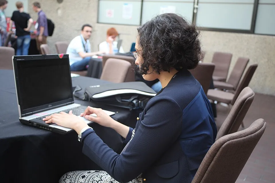 A participant typing on a laptop at a hackathon