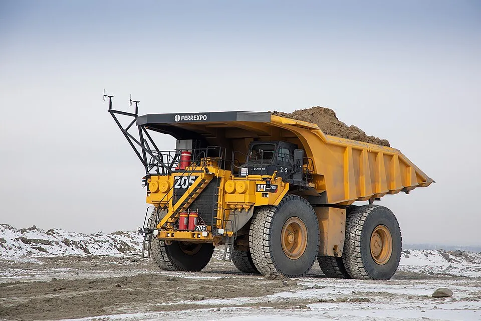 A giant yellow self-driving dump truck at an open-pit mine