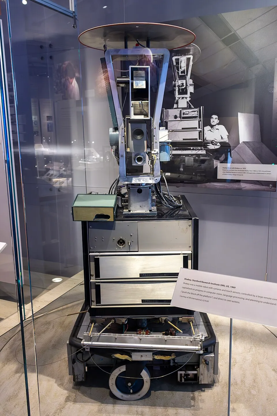 Shakey the robot, a tall box on wheels with a camera on top, at the Computer History Museum